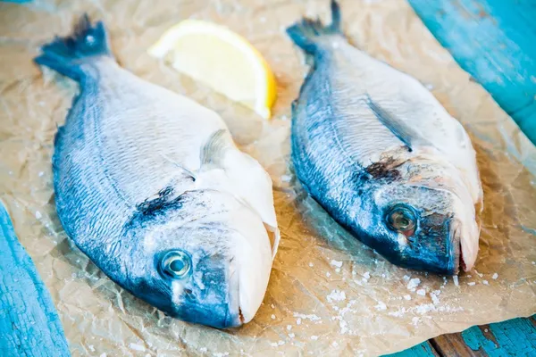 Két nyers dorada halak citrommal — Stock Fotó