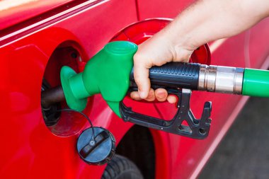 Person refueling a car at gas station clipart