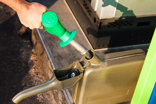 Homem que enche a lata com gasolina — Fotografia de Stock