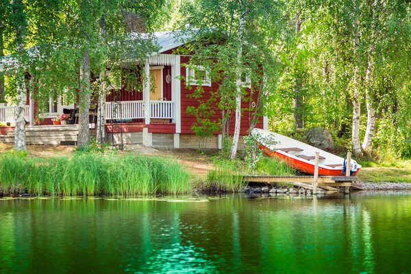 Old red Finnish summer cottage at a lake 