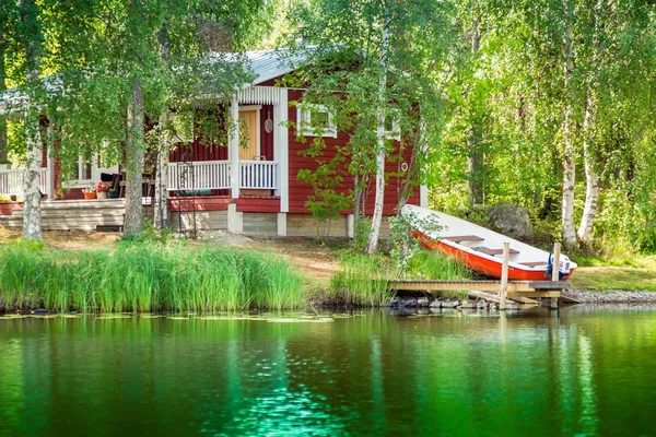 Velha casa de verão finlandesa vermelha em um lago Imagens Royalty-Free