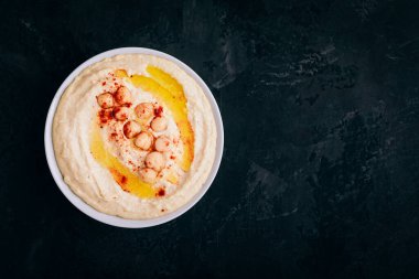 Zeytinyağlı humus ve koyu taşlı arka planda nohut. Üst görünüm, kopyalama alanı ile.