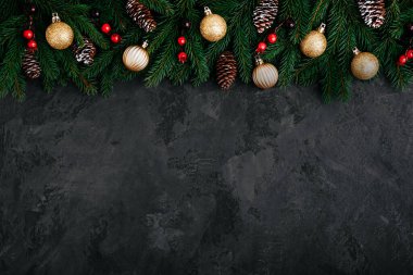 Yeşil köknar dalları, koniler ve altın ve kırmızı dekoru olan bir Noel arkaplanı. Kopyalama alanı olan üst görünüm