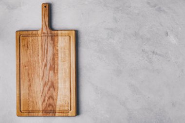 Gri beton arka planda tahta kesme tahtası. Kopyalama alanı olan üst görünüm.