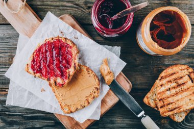 Ahşap arka planda reçelli fıstık ezmeli tost. Kahvaltı tostları..