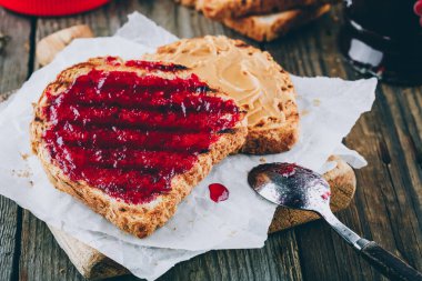 Ahşap arka planda reçelli fıstık ezmeli tost. Kahvaltı tostları..