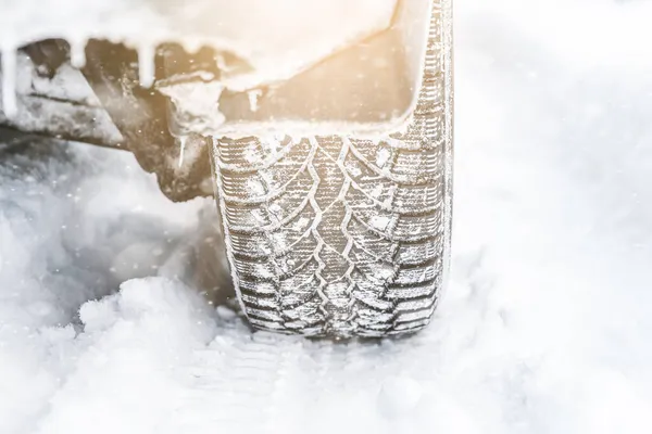 冬天的轮胎在积雪覆盖的冬季公路上对汽车轮胎进行近距离检查 — 图库照片