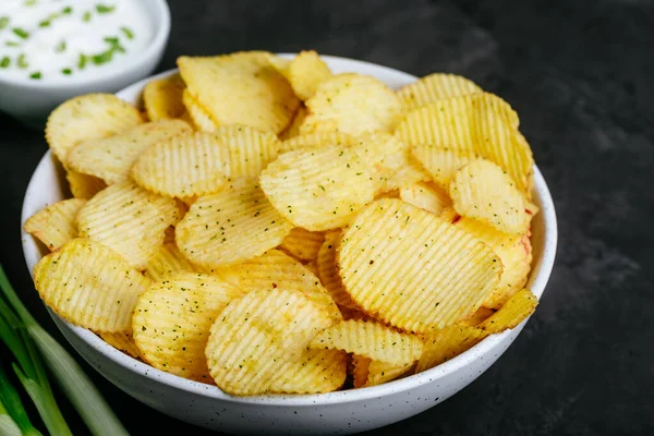 土豆片Potato Chips 脆薯片和酸奶油 碗中的洋葱 在黑暗的石头混凝土背景 复制空间 — 图库照片