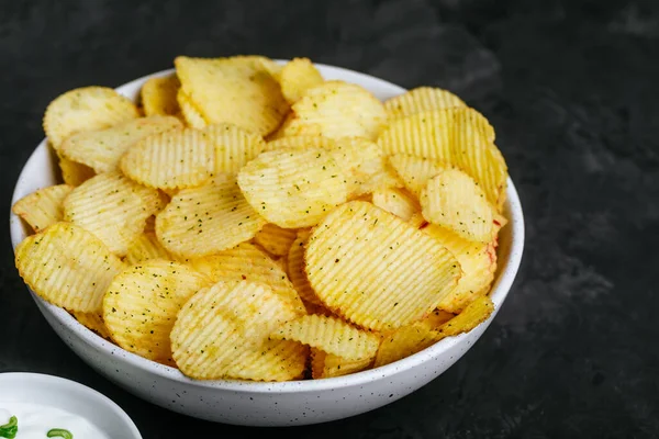 Burgonyaszirom Ropogós Burgonya Chips Tejföl Hagymával Tálban Sötét Beton Háttér — Stock Fotó