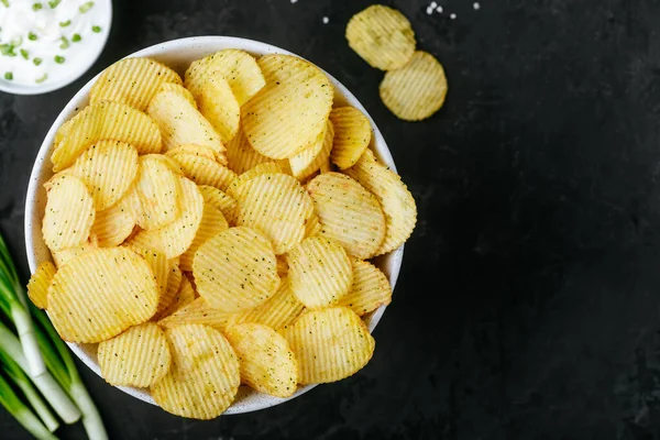 Burgonyaszirom Ropogós Burgonya Chips Tejföl Hagymával Tálban Sötét Beton Háttér — Stock Fotó