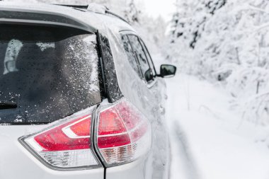 Car closeup on a winter road in snow covered forest. Winter landscape with car on the road and trees covered with snow
