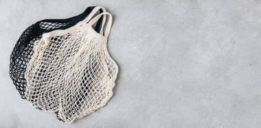 Gri taş zemin üzerinde boş pamuk ağları, kopya alanı ile üst görünüm. Sıfır atık, plastiksiz konsept.