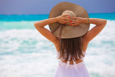 Genç moda kadını plajda dinleniyor.