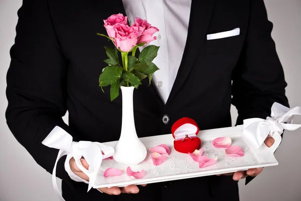 Hombre en ropa formal con anillo de compromiso y flores — Foto de Stock