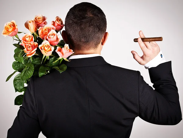 Young man in suit with bouquet of roses — Stock Photo, Image