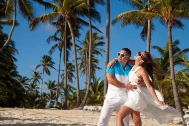 Plajda gelinlik giymiş güzel bir çift.