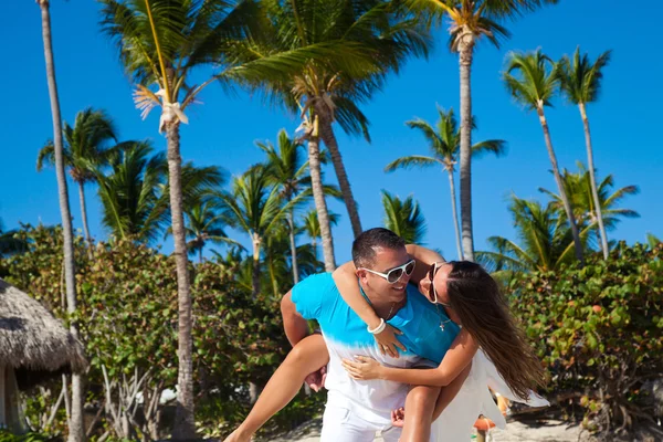 Homem dando passeio de piggyback para namorada na praia do Caribe — Fotografia de Stock