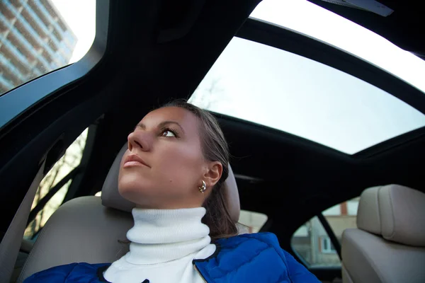 Jeune femme brune assise dans une voiture — Photo