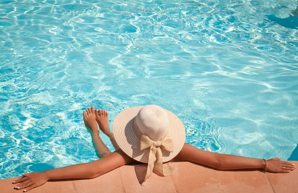 파란 수영장에서 편안한 수영장 모자에 있는 여자 — 스톡 사진