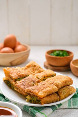 Martabak Telor veya Martabak Telur. Yumurta, et ve baharatla doldurulmuş tuzlu tavada kızartılmış hamur işi. Martabak Telur Endonezya sokak yemeklerinden biridir.