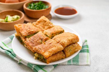 Martabak Telor veya Martabak Telur. Yumurta, et ve baharatla doldurulmuş tuzlu tavada kızartılmış hamur işi. Martabak Telur Endonezya sokak yemeklerinden biridir.