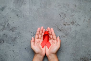 Eller kırmızı kurdele tutuyor, HIV farkındalığı konsepti, Dünya Yardım Günü, Dünya Hipertansiyon Günü
