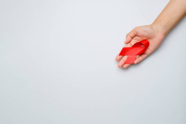 Eller kırmızı kurdele tutuyor, HIV farkındalığı konsepti, Dünya Yardım Günü, Dünya Hipertansiyon Günü