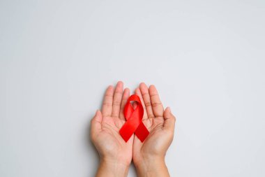 Eller kırmızı kurdele tutuyor, HIV farkındalığı konsepti, Dünya Yardım Günü, Dünya Hipertansiyon Günü