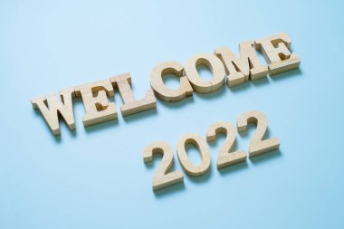 Mavi arkaplanda 2022 ahşap metin numarası var. Çözüm, plan, gözden geçirme, hedef, başlangıç ve yeni yıl tatili kavramları