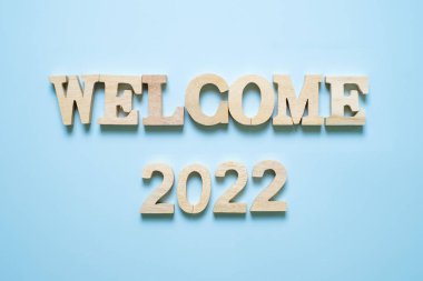 Mavi arkaplanda 2022 ahşap metin numarası var. Çözüm, plan, gözden geçirme, hedef, başlangıç ve yeni yıl tatili kavramları