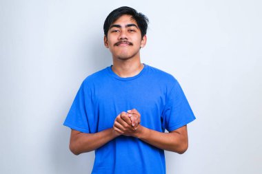 İzole edilmiş beyaz arka planda el ele tutuşmuş rahat ve neşeli gülümseyen genç ve yakışıklı bir adam. Başarı ve iyimser