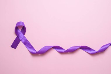 Dünya Kanser Günü 'nün pembe arkaplan üzerindeki sembolü olarak mor kurdele.