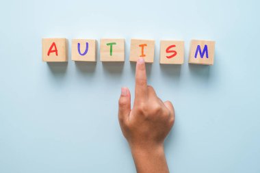 Çocuklar ahşap karelerde el ve otizm mavi arka planda üst manzara. Asperger Günü konsepti