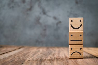 Müşteri hizmetleri değerlendirmesi ve memnuniyet anketi hizmet değerlendirmesi kavramları. Müşteri elini kapat ve masadaki gülen yüz simgesini seç..