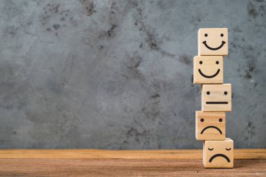 Müşteri hizmetleri değerlendirmesi ve memnuniyet anketi hizmet değerlendirmesi kavramları. Müşteri elini kapat ve masadaki gülen yüz simgesini seç..