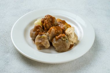 Siomay Bandung ya da buğulanmış mantı, baharatlı fıstık soslu geleneksel Endonezya sokak yemeği ve soya sosu beyaz tabakta servis edilir..