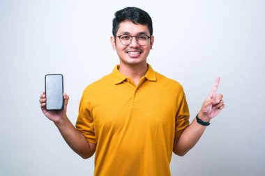 Yakışıklı Asyalı genç adam beyaz izole edilmiş arka plan üzerinde akıllı telefon ekranı gösteriyor.