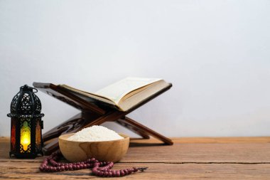 Kutsal Kur 'an ve tahtadan bir kase içinde pirinç, tahta bir masa üzerinde, İslami zeka kavramı..