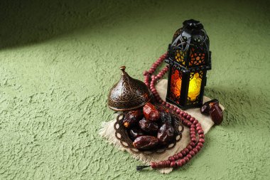 Aydınlatılmış Fas dekoratif lambası ve eski antika bir tabakta hurmalar. Ramazan arkaplan kavramı