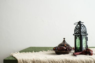 Ramazan Kareem tebrik kartı, davetiye. Fas feneri ve yanan bir mum. Eski ahşap arka planda Türk kasesi üzerine tarihler
