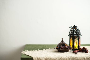 Ramazan Kareem tebrik kartı, davetiye. Fas feneri ve yanan bir mum. Eski ahşap arka planda Türk kasesi üzerine tarihler