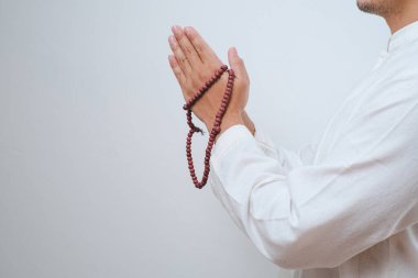 El tasbih ya da beyaz arkaplanda tespih tutarken kapat