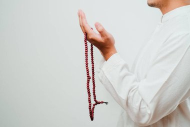 El tasbih ya da beyaz arkaplanda tespih tutarken kapat