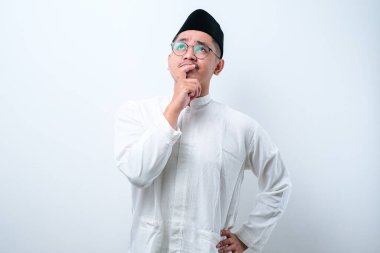 Asyalı Müslüman adam jestler yapıyor, beyaz arka planda fikir arıyor.
