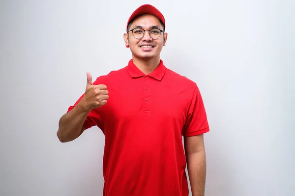 Asian Delivery Man Red Uniform Cap Smiling Showing Thumb Isolated — Zdjęcie stockowe