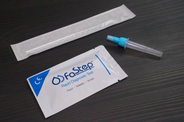 Ottawa, Ontario, Kanada - 9 Şubat 2022: Bir Güvence Teknisyeni Fay Hızı COVID-19 antijen test paketi bir test çubuğu ve şişe ile bir tahta masanın üzerinde yatıyor.