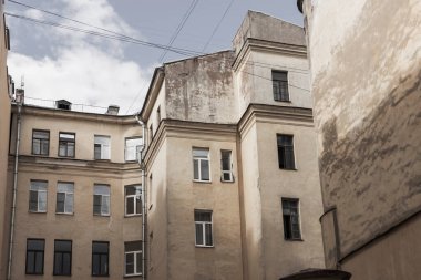 St. Petersburg 'un merkezindeki avluda yürüyüş. Eski bir binanın sarı duvarları.