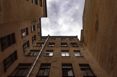 St. Petersburg 'un merkezindeki avluda yürüyüş. Eski bir binanın sarı duvarları.