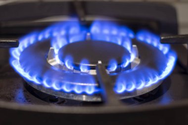 Karanlıktaki doğal gazın mavi alevi. Mutfak sobasında yanan bir gaz ocağı..