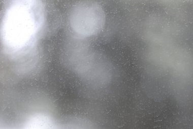 Pencere camında kirli lekeler ve yağmur damlaları var. Camların yüzeyi, lekeler ve tozla kaplıydı..